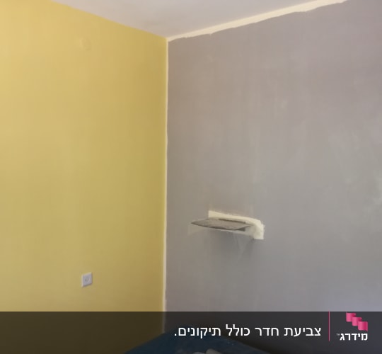 קיר צבוע בצהוב ואפור עם מדף קטן
